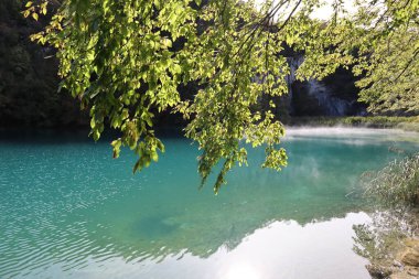 Açık mavi suyla gölün manzarası, suyun üstünde sis, Plitvice Gölleri Ulusal Parkı 'nda sonbahar.