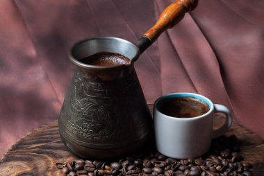 Cezve 'de kahve ve kırmızı arka planda beyaz bardak.