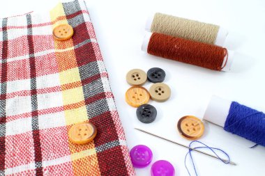 renkli düğme iğne iplik ve kumaş.