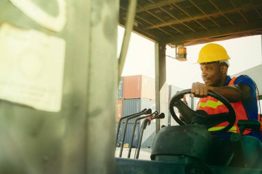 African-American male workers wear safety clothing in a warehouse carrying cargo containers , Expertise, expertise in driving work during the day. clipart
