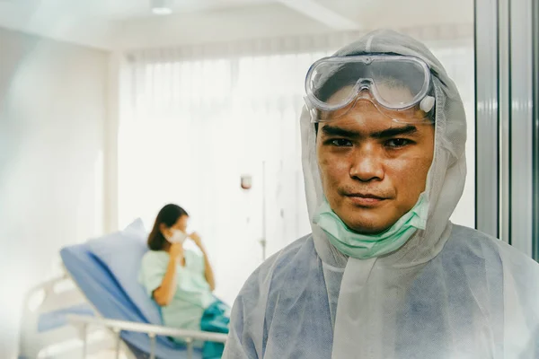 Portrait of a male doctor with weariness, weary face and scars from wearing a mask, always working, to take care of female patients with the Coronavirus Covid-19 flu at a hospital detention facility.