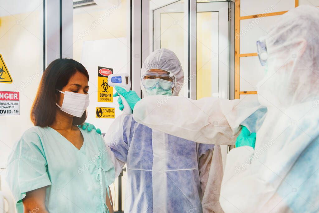 Medical team uses a digital thermometer for middle aged women with high fever to be admitted to the quarantine room of the hospital : Measures to prevent people infected with Covid-19