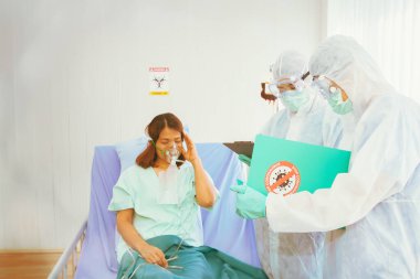 Tıbbi ekipler Coronavirus (Covid-19) enfeksiyonu olan hastaları tedavi ederken semptomları yakından izler. Bir hastane karantina odasında baş ağrısı ve yüksek ateşle.