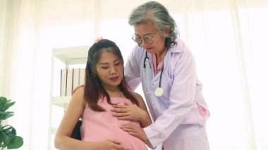 Kıdemli kadın doğum uzmanı hamile bir kadınla sağlık ve doğum öncesi hazırlıkları tartışıyor ve tavsiyelerde bulunuyor. Doktor merhamet gösterecektir ve hastaya en iyi şekilde bakacaktır..