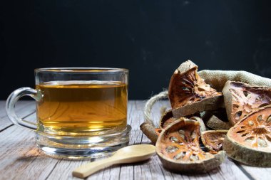 Kurutulmuş Bael Fruit ve Bael Meyve Suyu. Masanın üzerinde temiz cam bir yerde. Isıyı iyileştiren, susuzluğu gideren, tazeliği sağlayan özellikleri var..