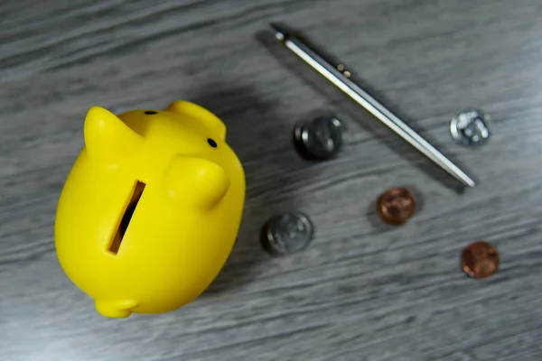 Yellow pig piggy bank placed on desk (financial planning concept) top view