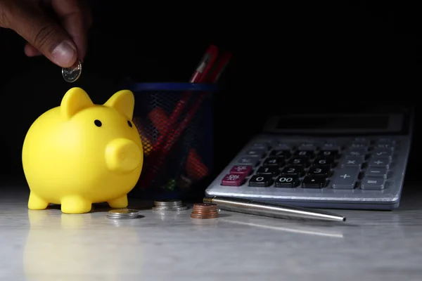 Yellow pig piggy bank is saving with coin money placed on desk (financial planning concept)