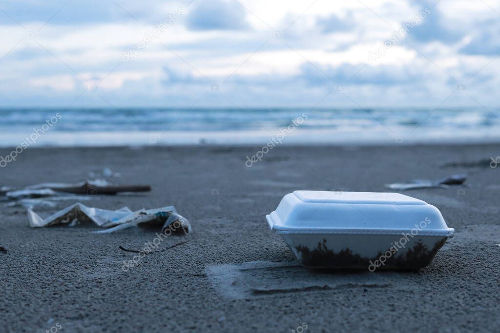 Rubbish (foam boxes) discarded on the beach.The background is sea