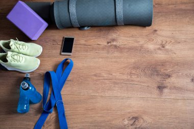 Evde birkaç sahne donanımı ve teçhizatla egzersiz yapan bir kadın.