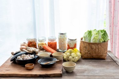 Kimchi 'nin bileşenleri olan ahşap masadaki birçok bitki ve taze sebzeler Kore kültürünün gıda konseptine fermantasyon korumasıdır..