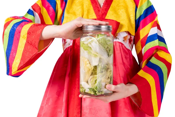 Korean woman is wearing a traditional hanbok, she holding a glass bottle containing Kimchi, which is Korean culture fermentation preservation, On white isolated background. — Stock Image Korean Woman Wearing Traditional Hanbok She Holding Glass Bottle Containing Royalty Free Stock Images