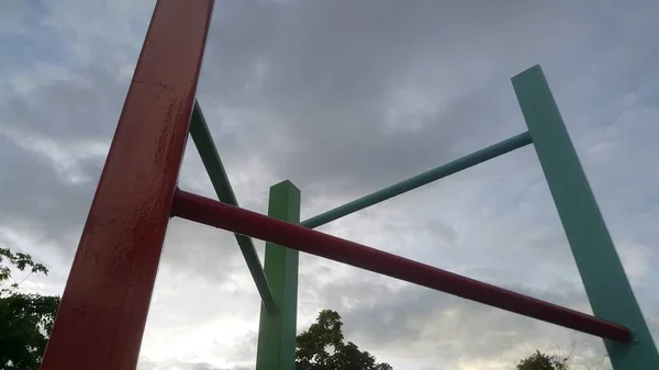 Grüne Und Rote Stahlstangen Zum Klettern Und Schwarze Wolken Abend — Stockfoto