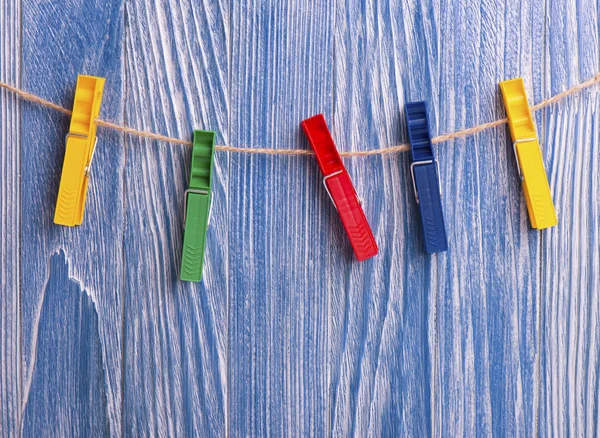 Colorful plastic clothespins on blue wooden background — Stock Photo, Image