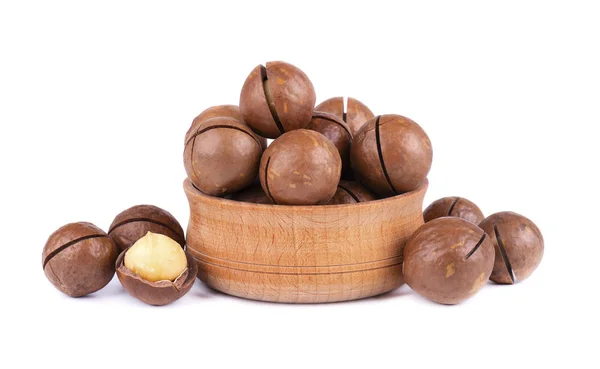 Macadamianötter på träplatta, isolerad på vit bakgrund. Skalade och oskalade macadamia. — Stockfoto