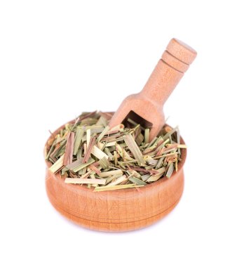 Tahta bir kase ve kaşık, beyaz bir arka plan üzerinde izole Lemongrass. Doğal limon otu kuru sprigs.