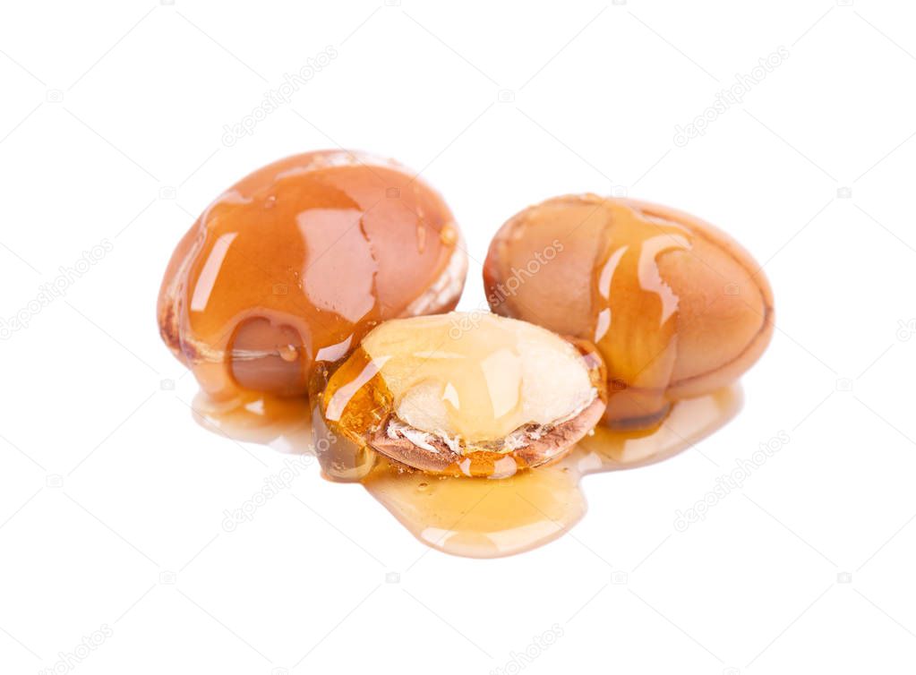 Argan seeds, isolated on a white background. Argan nuts and oil, for cosmetic and beauty products. Natural argan fruit from Morocco.