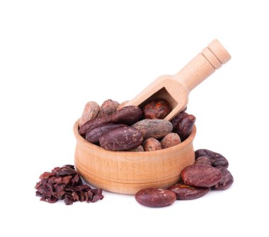 Tahta kasede kakao çekirdeği soyulmuş, beyaz arka planda izole edilmiş. Ahşap kaşıkta kavrulmuş ve aromatik kakao çekirdeği, doğal çikolata..