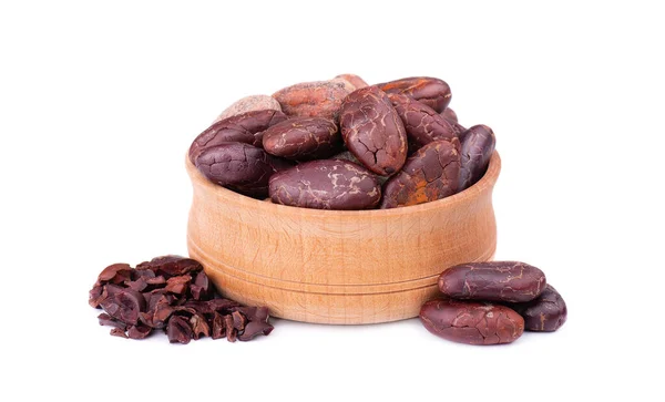 V dřevěné míse loupané kakaové boby, izolované na bílém pozadí. Pražené a aromatické kakaové boby, přírodní čokoláda. — Stock fotografie