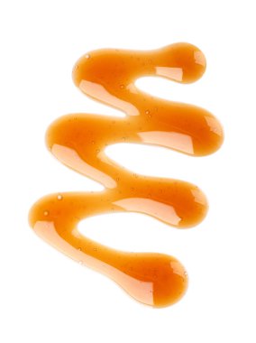 Karamel şurubu damlabeyaz arka plan üzerinde izole. Tatlı karamel sosu sıçramaları. Üstte görüntü