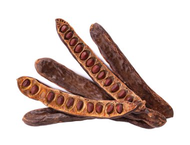 Olgun keçiboynuzu kabukları ve beyaz arka planda izole fasulye. Üst görünüm