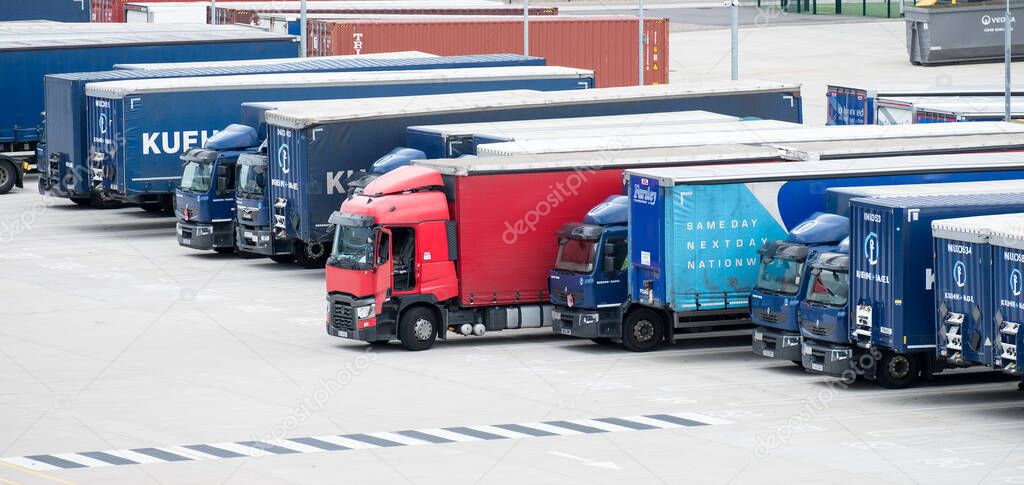 Red truck in a line of blue trucks