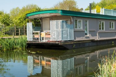 House boat moored on a canal clipart