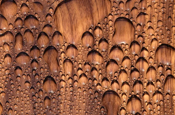 Water beads on a dark wood surface