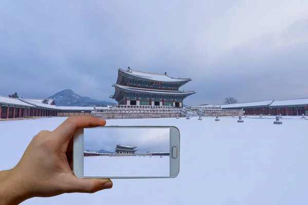 Güney Kore, Seul 'de kar yağarken Gyeongbokgung Sarayı' nda cep telefonuyla Gyeongbokgung Sarayı 'nın fotoğrafını çekiyorlar..