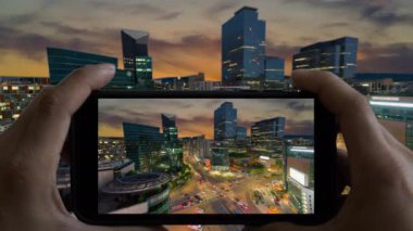 Touchscreen Smart Phone 'un hızlandırılmış video kaydı. Güney Kore 'deki Gangnam Meydanı' nda trafik alacakaranlığı.