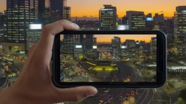 Touchscreen Smart Phone 'un hızlandırılmış video kaydı. Namdaemun Kapısı Seul Güney Kore 'de gün batımında.