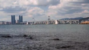 Busan Gwangalli Plajı ve Gwangan Köprüsü 'nde bulutlu bir gökyüzü. Ya da Güney Kore 'nin en iyi simgesi olan Güney Kore Elmas Köprüsü. (yakınlaştır)