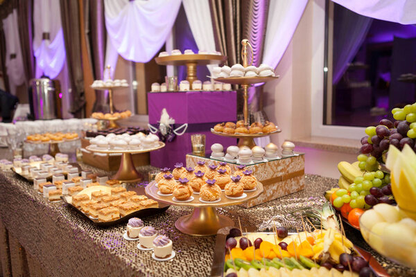 Banquet table with different food snacks, appetizers and dessetr