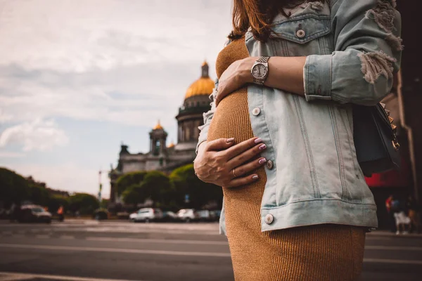 Mujer embarazada joven de pie junto a la gran ciudad — Foto de Stock