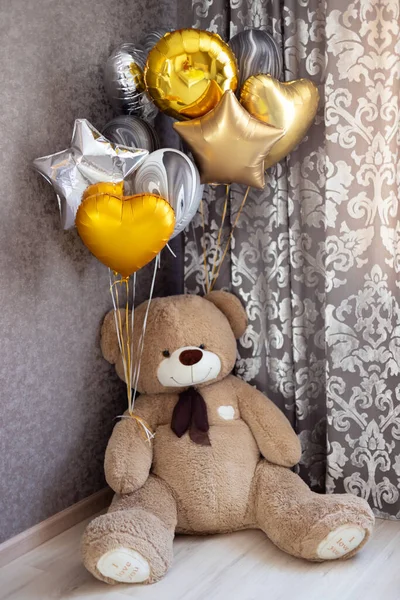 Arka planda renkli toplardan yapılmış oyuncak bir balon var..