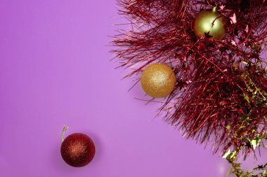 Noel kompozisyonu. Noel kırmızı ve sarı süslemeler ve pembe arka planda yeni yıl süsleri ve yıldızlar. 