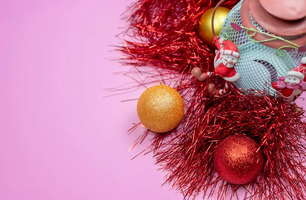 Noel kompozisyonu. Pembe arka planda kırmızı ve sarı Noel süslemeleri. Düz şezlong, üst görünüm, boşluğu kopyala
