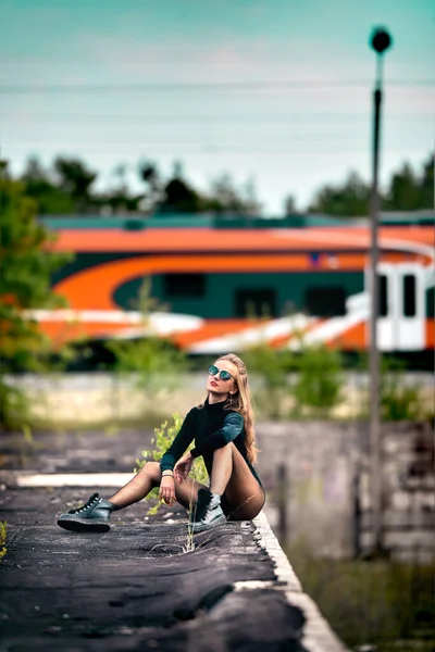 Atrakcyjna kobieta siedzi na dachu, podczas gdy pociąg jedzie do przodu.. — Zdjęcie stockowe