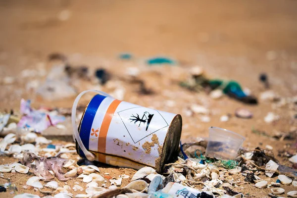 A jar with toxic chemicals on a beach sand. Waste problem in ocean.