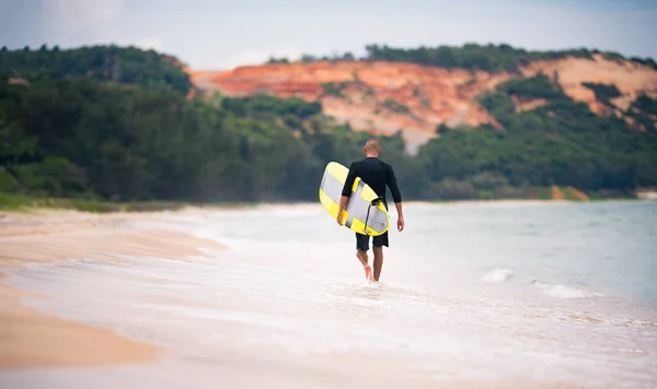 Müder Surfer mit gelbem Surfbrett unterwegs. Sommerferienkonzept. — Stockfoto