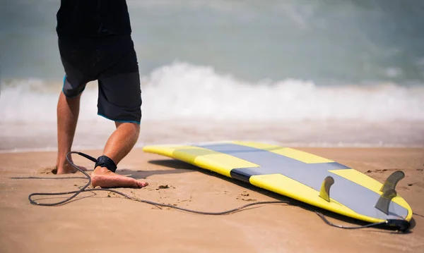 Fit surf oktató mutatja a napos strandon, hogyan kell állni a szörfdeszkán. Szörfözés iskolai víz sport órák nyári szörf tábor nyaralás. — Stock Fotó