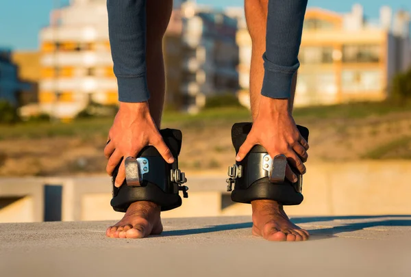 Homem em botas anti gravidade ou inversão de cabeça para baixo pendurado na barra horizontal. Equipamento desportivo. — Fotografia de Stock