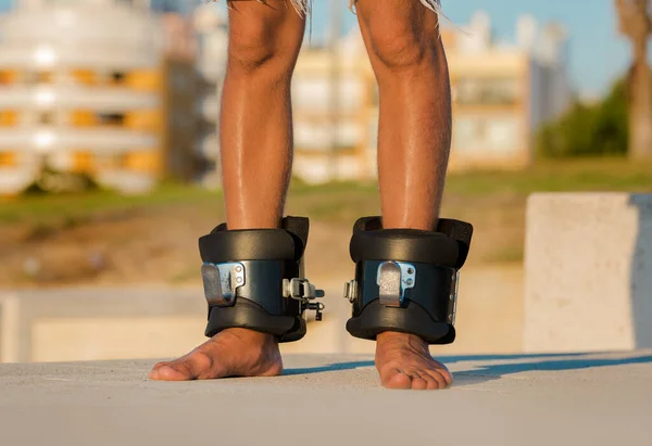反重力または反転ブーツの男が逆さまにぶら下がっている。スポーツ用具。ブーツは背部苦痛、筋肉の緊密、および痙攣を減らすのを助ける。首、肩の筋肉や背中を伸ばすのに役立ちます. — ストック写真
