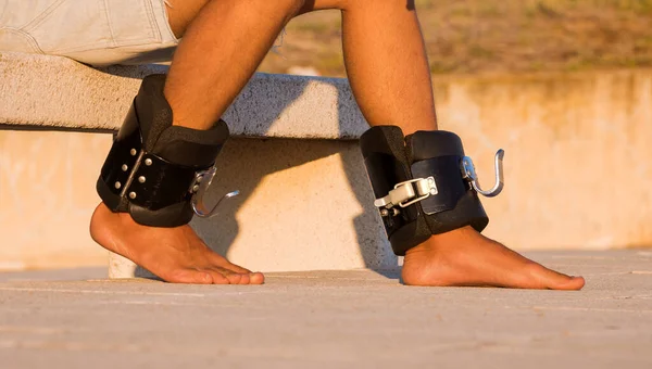 Homem em botas anti gravidade ou inversão pronto para de cabeça para baixo pendurado na barra horizontal. Equipamento desportivo. — Fotografia de Stock