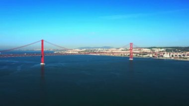 25 Nisan Köprüsü 'nün hava görüntüsü ya da insansız hava aracı görüntüsü. Kırmızı köprü Lizbon ve Almada 'yı birbirine bağlıyor, Portekiz. Tagus Nehri.