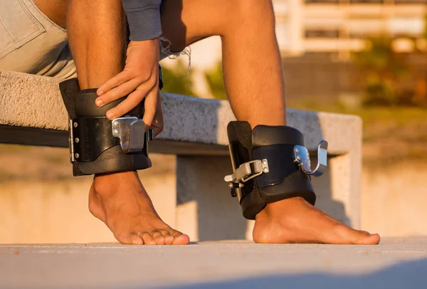 Homem vestindo botas anti gravidade ou inversão pronto para de cabeça para baixo pendurado na barra horizontal. Equipamento desportivo. — Fotografia de Stock