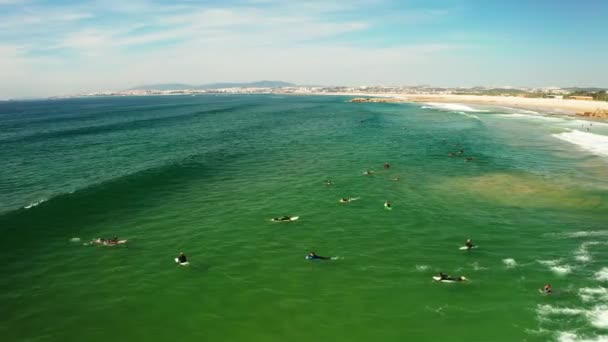 Вид с высоты птичьего полета на множество неузнаваемых серферов, ловящих волны в Португалии Стоковый Видеоролик