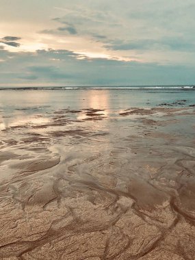 Sahili olan deniz gün doğumunda