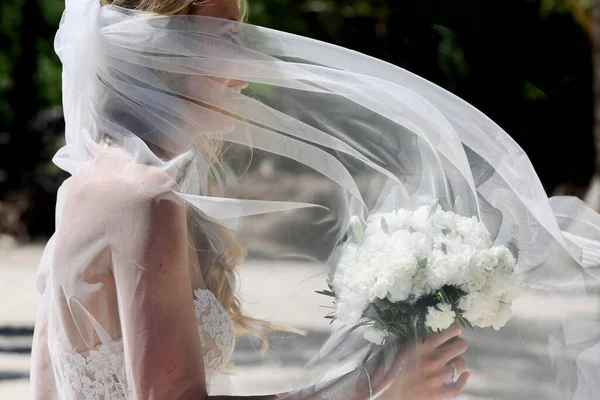 ビーチで長い髪と花束の花の結婚式の装飾を持つ花嫁 — ストック写真