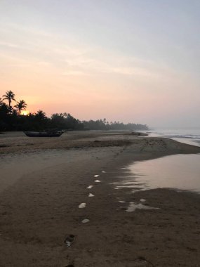 Tropikal bölgede kızıl gökyüzü olan plajda gün doğumu ya da gün doğumu