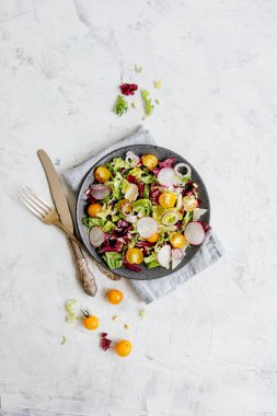 Keten peçeteyle servis edilen dokuma masasında taze sebzeli salata.